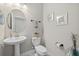 Modern powder room featuring pedestal sink, decorative mirror, and contemporary fixtures at 2818 Starwood Ct, Lakewood Ranch, FL 34211