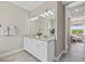 Bright bathroom with double sink vanity, granite countertop and tile flooring leading to the bedroom at 2818 Starwood Ct, Lakewood Ranch, FL 34211