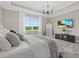 Well-lit bedroom features a tray ceiling, light wood floors, and a large window with outdoor views at 2818 Starwood Ct, Lakewood Ranch, FL 34211