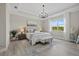 Bright bedroom featuring a tufted headboard, chandelier lighting, and scenic outdoor views at 2818 Starwood Ct, Lakewood Ranch, FL 34211