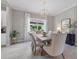 An elegant dining room featuring a modern chandelier and ample natural light, adjacent to the kitchen at 2818 Starwood Ct, Lakewood Ranch, FL 34211