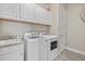 Well-equipped laundry room featuring modern washer and dryer units, and white cabinetry at 2818 Starwood Ct, Lakewood Ranch, FL 34211