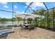 Outdoor dining on a brick patio within a screened enclosure, pool and a lovely lake view at 2818 Starwood Ct, Lakewood Ranch, FL 34211