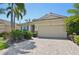 Well-manicured single Gathering home featuring a clay tile roof, brick driveway, and tropical landscaping at 3018 Oriole Dr, Sarasota, FL 34243