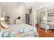 Cozy bedroom featuring hardwood floors, floral bedding, mirrored closet and ceiling fan at 337 Somerset Ave, Sarasota, FL 34243