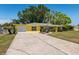 Charming exterior view of the home with well-manicured lawn, landscaping, and a driveway at 337 Somerset Ave, Sarasota, FL 34243
