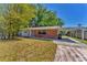 Quaint brick home with a covered carport and mature landscaping at 3545 Lalani Blvd, Sarasota, FL 34232