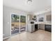 Modern kitchen with gray cabinets, black appliances, and sliding glass door to backyard at 3545 Lalani Blvd, Sarasota, FL 34232