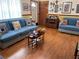 Cozy living room featuring wood flooring, comfortable sofas, and a variety of decorative wall hangings at 3612 27Th W Ave, Bradenton, FL 34205