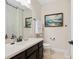 Bathroom featuring dark wood vanity, neutral countertop and framed art of ocean waves at 3623 Pitch Ln, Sarasota, FL 34232