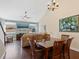 A dining room featuring hardwood floors, a chandelier, and a view of the living room at 3623 Pitch Ln, Sarasota, FL 34232