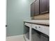 Functional laundry room with front-loading washer and dryer and overhead cabinets at 3623 Pitch Ln, Sarasota, FL 34232
