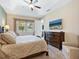 Main bedroom featuring carpeted floors, a tray ceiling, and a view of the TV and windows at 3623 Pitch Ln, Sarasota, FL 34232