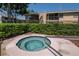 Relaxing community hot tub with tiled surround and metal grab rail at 3810 N Oak Dr # N61, Tampa, FL 33611