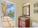 Bathroom vanity featuring granite counters, wood cabinets, and access to screened in pool at 4173 Westbourne Cir, Sarasota, FL 34238
