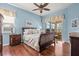 Bedroom features warm wood flooring, cool blue walls, and a patio view at 4173 Westbourne Cir, Sarasota, FL 34238
