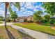 Beautiful home with a well-manicured lawn, palm trees, and inviting curb appeal at 4173 Westbourne Cir, Sarasota, FL 34238
