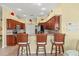 Kitchen with barstool seating at granite counter; stainless steel appliances and warm wood cabinetry at 4173 Westbourne Cir, Sarasota, FL 34238