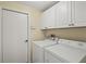 Functional laundry room with a washer, dryer, and built-in cabinets, providing an organized space for laundry tasks at 4173 Westbourne Cir, Sarasota, FL 34238