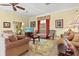 Inviting living room with plush sofas, a floral rug, and a large window with decorative curtains at 4173 Westbourne Cir, Sarasota, FL 34238
