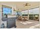 Enclosed patio with a grill, ceiling fan, and dining area, perfect for outdoor cooking and relaxation at 4173 Westbourne Cir, Sarasota, FL 34238