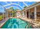 A stunning screened-in pool with brick pavers and steps leads to a lanai and outdoor grill at 4173 Westbourne Cir, Sarasota, FL 34238