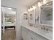 Bathroom with double sinks and view into bedroom with bed and window; tiled shower area at 4211 73Rd E Ter, Sarasota, FL 34243