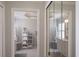 Hallway view into ensuite bathroom featuring double sinks, white tile floor, and mirrored closet at 4211 73Rd E Ter, Sarasota, FL 34243