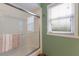 Bathroom featuring a white tiled shower with glass doors and a window bringing in natural light at 4211 73Rd E Ter, Sarasota, FL 34243