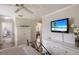 Bedroom with white dresser and mounted TV; view into living room with arched doorway in bright home at 4211 73Rd E Ter, Sarasota, FL 34243