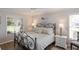 Cozy bedroom offers natural light from large windows and features a stylish wrought iron bed frame and neutral decor at 4211 73Rd E Ter, Sarasota, FL 34243