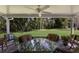 Relaxing covered patio with wicker furniture and a glass-top table, overlooking the green backyard at 4211 73Rd E Ter, Sarasota, FL 34243