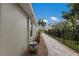 Exterior walkway featuring lush tropical plants, a black fence, and neutral house siding at 4211 73Rd E Ter, Sarasota, FL 34243