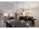Open kitchen and dining area with an island bar, pendant lighting, and stainless steel appliances; flows to the living room at 4211 73Rd E Ter, Sarasota, FL 34243