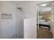 Bright shower with marble tiling plus view into bedroom with a comfortable bed and stylish floors at 4211 73Rd E Ter, Sarasota, FL 34243