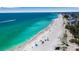 Stunning aerial view of a white sand beach with crystal clear turquoise water and people enjoying the sunshine at 4307 Gulf Dr # 109, Holmes Beach, FL 34217