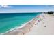 Scenic aerial view of a sandy beach with clear blue water and scattered beachgoers at 4307 Gulf Dr # 109, Holmes Beach, FL 34217