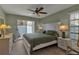 A serene bedroom is furnished with a ceiling fan, tile flooring, and a sliding door with access to the outdoors at 4307 Gulf Dr # 109, Holmes Beach, FL 34217