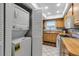 This view showcases a washer/dryer concealed in a closet adjacent to a kitchen with wood cabinets and tiled floor at 4307 Gulf Dr # 109, Holmes Beach, FL 34217