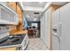 Well-lit kitchen featuring a white refrigerator, range, and tile flooring, with a glimpse into the adjacent dining area at 4307 Gulf Dr # 109, Holmes Beach, FL 34217