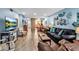 Open living room featuring coastal decor, stone accent wall and wood flooring at 4307 Gulf Dr # 109, Holmes Beach, FL 34217