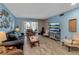 Cozy living room with bright blue walls, wood floors, fireplace, sofa, and walk-out access to patio at 4307 Gulf Dr # 109, Holmes Beach, FL 34217