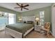 Bright main bedroom with king bed, ceiling fan, rocking chair, and a large window offering lots of natural light at 4307 Gulf Dr # 109, Holmes Beach, FL 34217