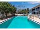 Large in-ground community pool with clear water, white fencing, lounge chairs, and a cabana at 4307 Gulf Dr # 109, Holmes Beach, FL 34217