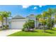 Charming single-story home with a well-manicured lawn and lush tropical landscaping with beautiful palm trees at 4325 Renwick Dr, Parrish, FL 34219