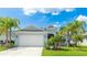 Beautiful single-story home features tropical landscaping, a well-kept lawn, and an attached two-car garage at 4325 Renwick Dr, Parrish, FL 34219