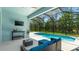 Outdoor living space with cozy blue seating area, TV, and screened pool view at 4325 Renwick Dr, Parrish, FL 34219