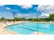 Community swimming pool with blue water, surrounded by a brick patio and lush landscaping for a relaxing experience at 4325 Renwick Dr, Parrish, FL 34219