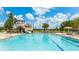 Resort-style pool with a slide, palm trees, and clear blue water, perfect for Gathering fun and relaxation at 4325 Renwick Dr, Parrish, FL 34219
