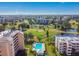 Expansive aerial view of a golf course and a community pool surrounded by condominium buildings, trees, and ponds at 4460 Fairways Blvd #604 Blvd # 604, Bradenton, FL 34209